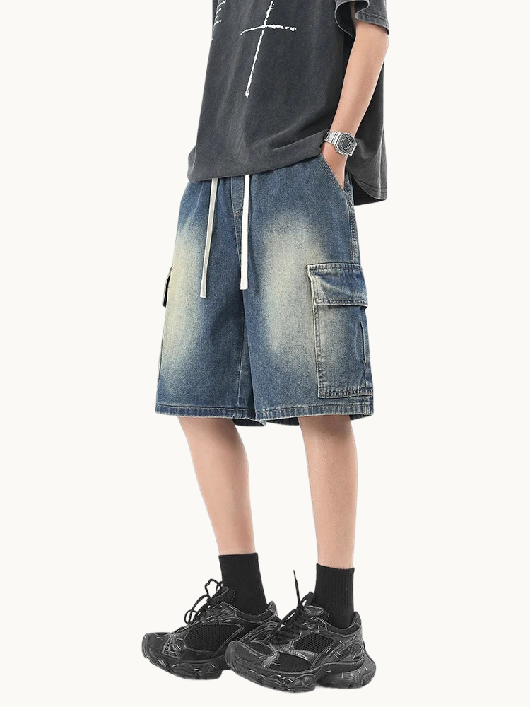 a man wearing a black t - shirt and denim shorts